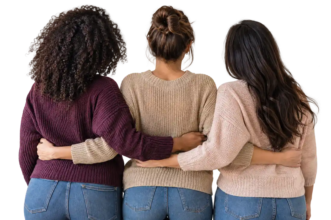 Três mulheres se abraçam em um gesto de união e acolhimento. Imagem ilustrativa.